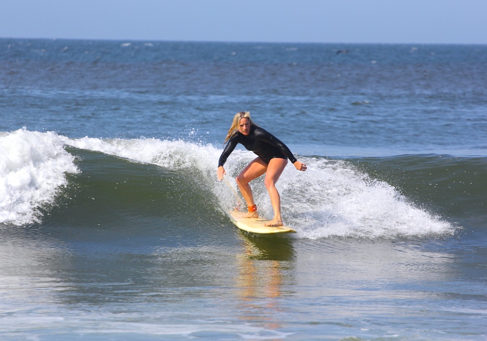 Female surfer riding a left wave in Los Organos Peru surf camp