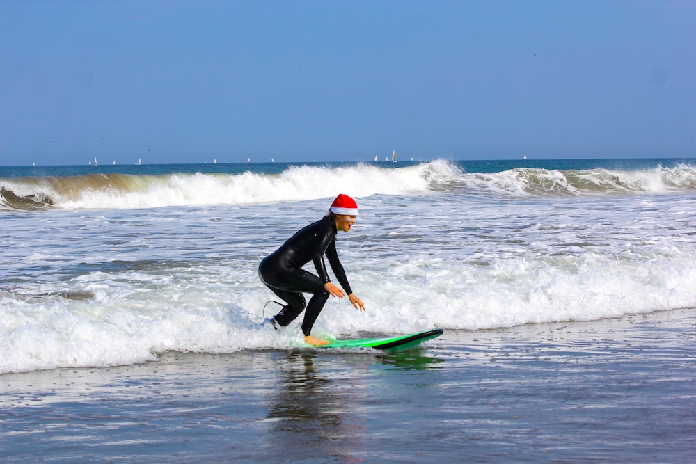 Christmas surf lesson in Peru and a beginner surfer stading up and surfing white water in Peru