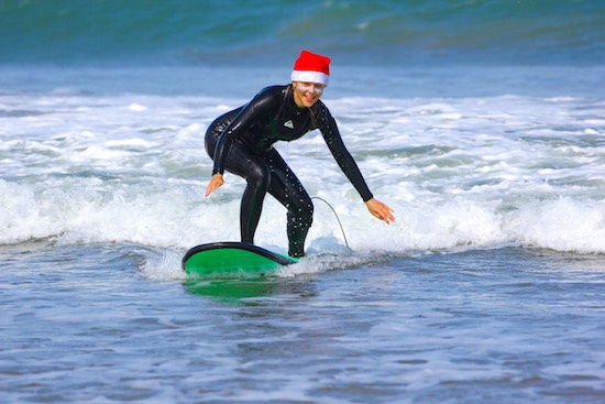 A beginner female surfer learning to surf with Surf Racer´s Learn to Surf & Stay package during Christmas holidays in Peru