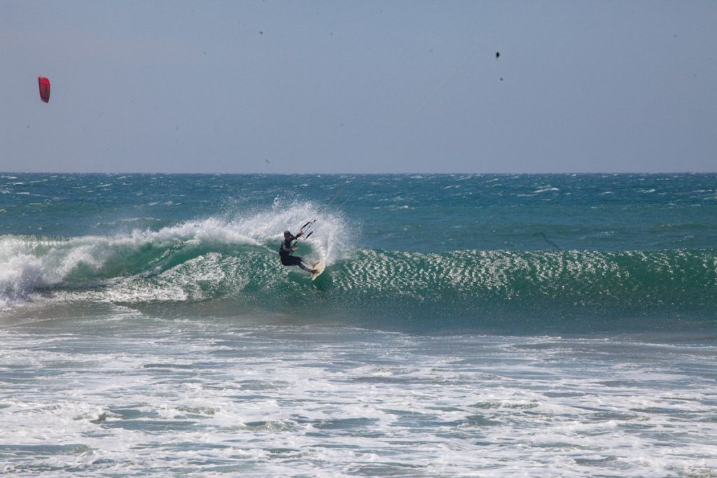 Female kiter riding waves in Peru